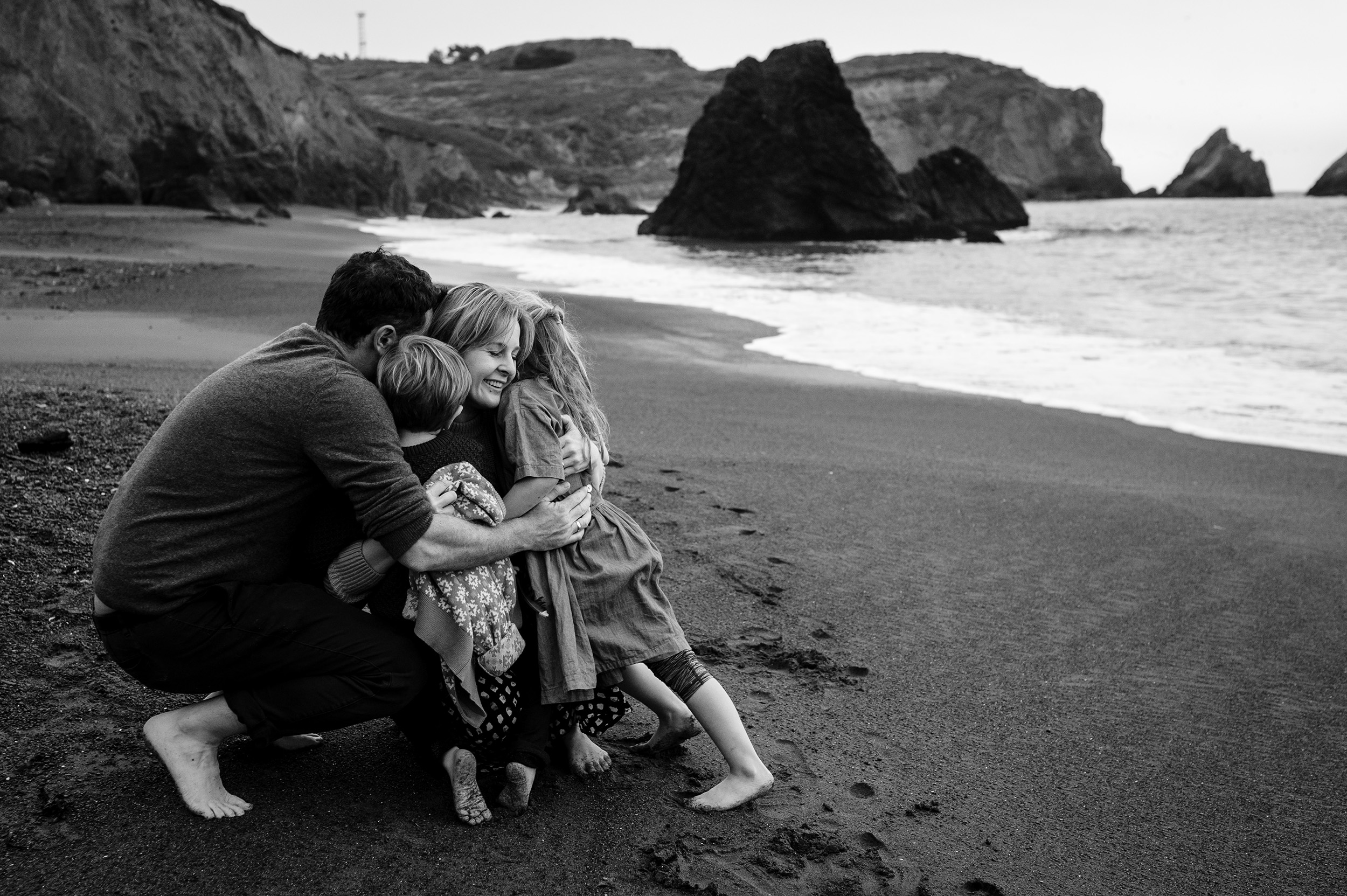 family hugging at the beach