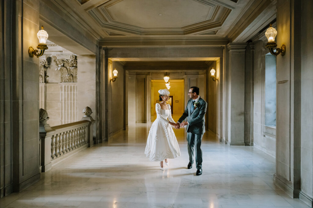 bride and groom walking the halls on their wedding at SF City Hall